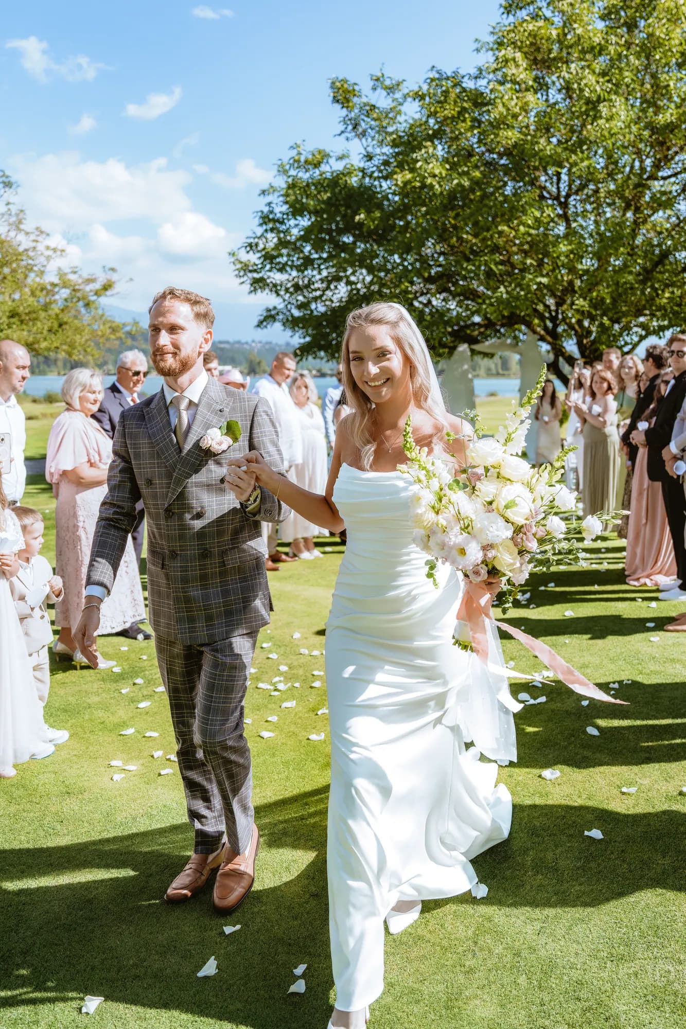 Newlyweds walking back down the aisle as guests throw confetti over them
