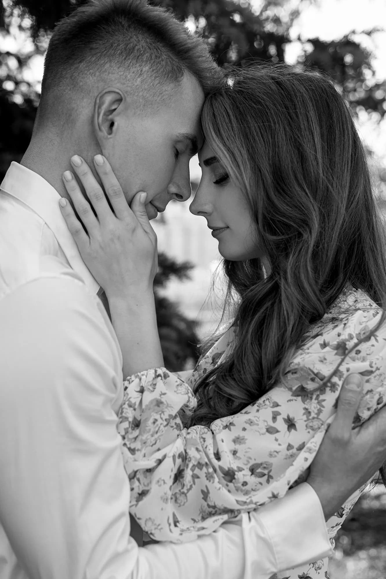 Black and white photograph of a couple resting their foreheads together, eyes closed