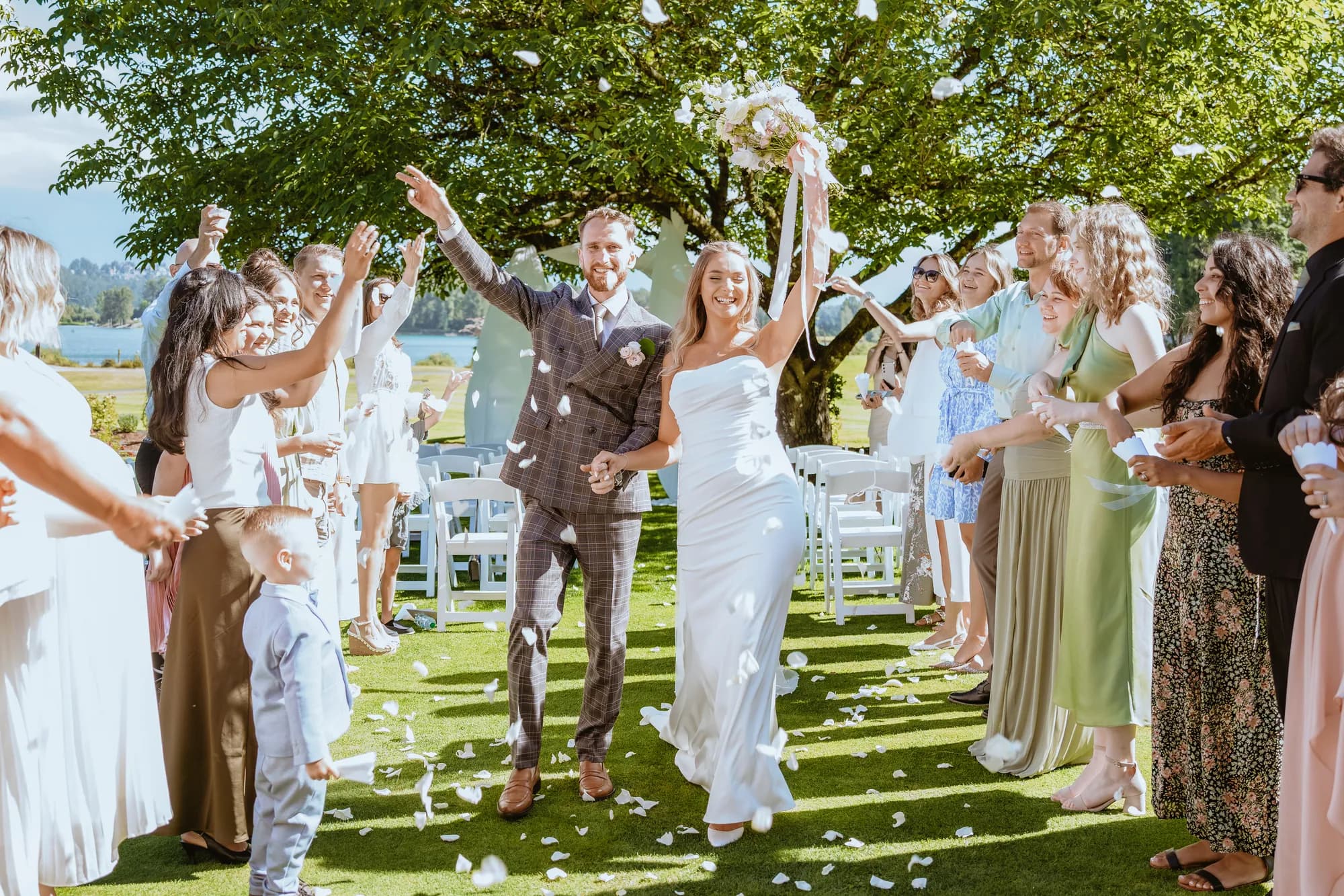 Guests showering the newlyweds with confetti as they walk back up the aisle